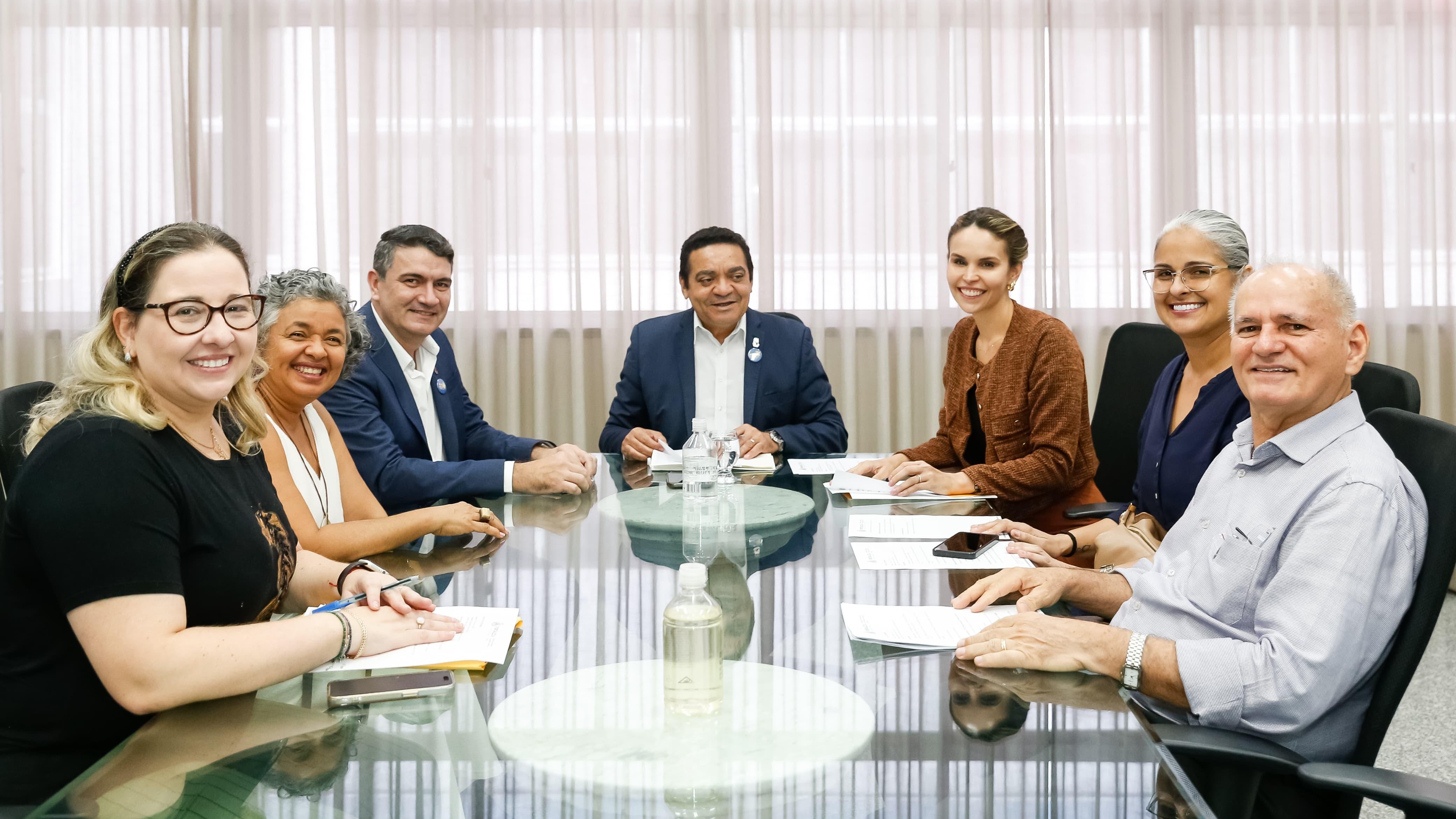 grupo reunido ao redor de uma mesa em um gabinete